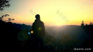 男人站在山顶看日出